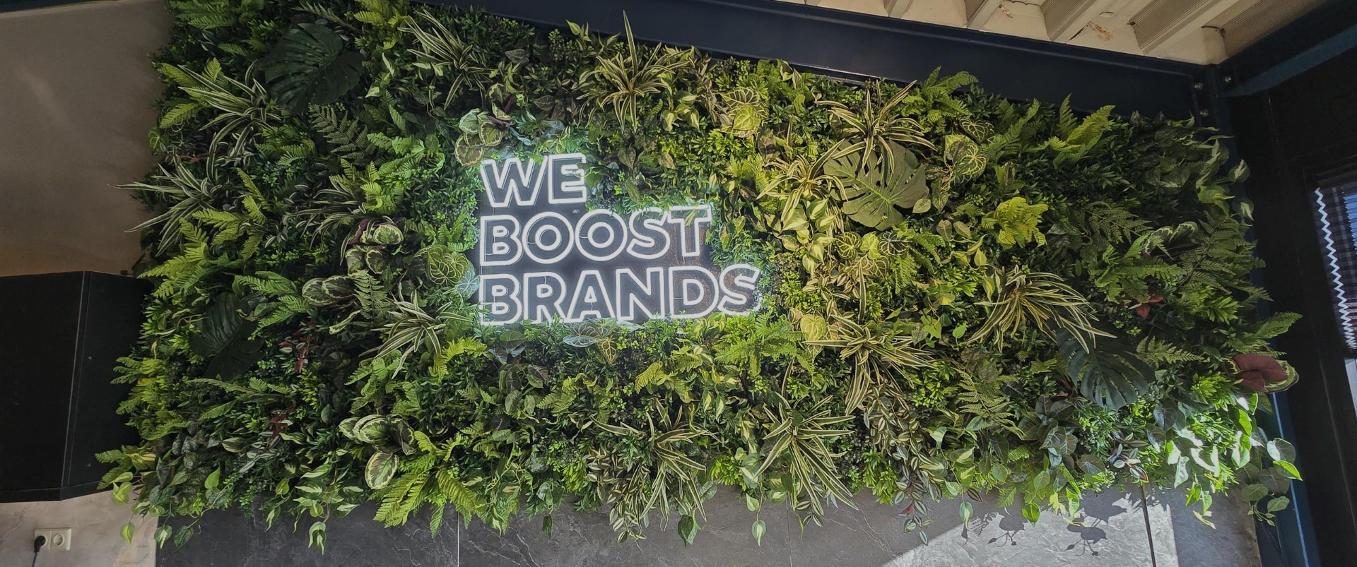 Kunstplantenwand met Neon logo bij We Boost Brands geplaatst door Het Style Concept